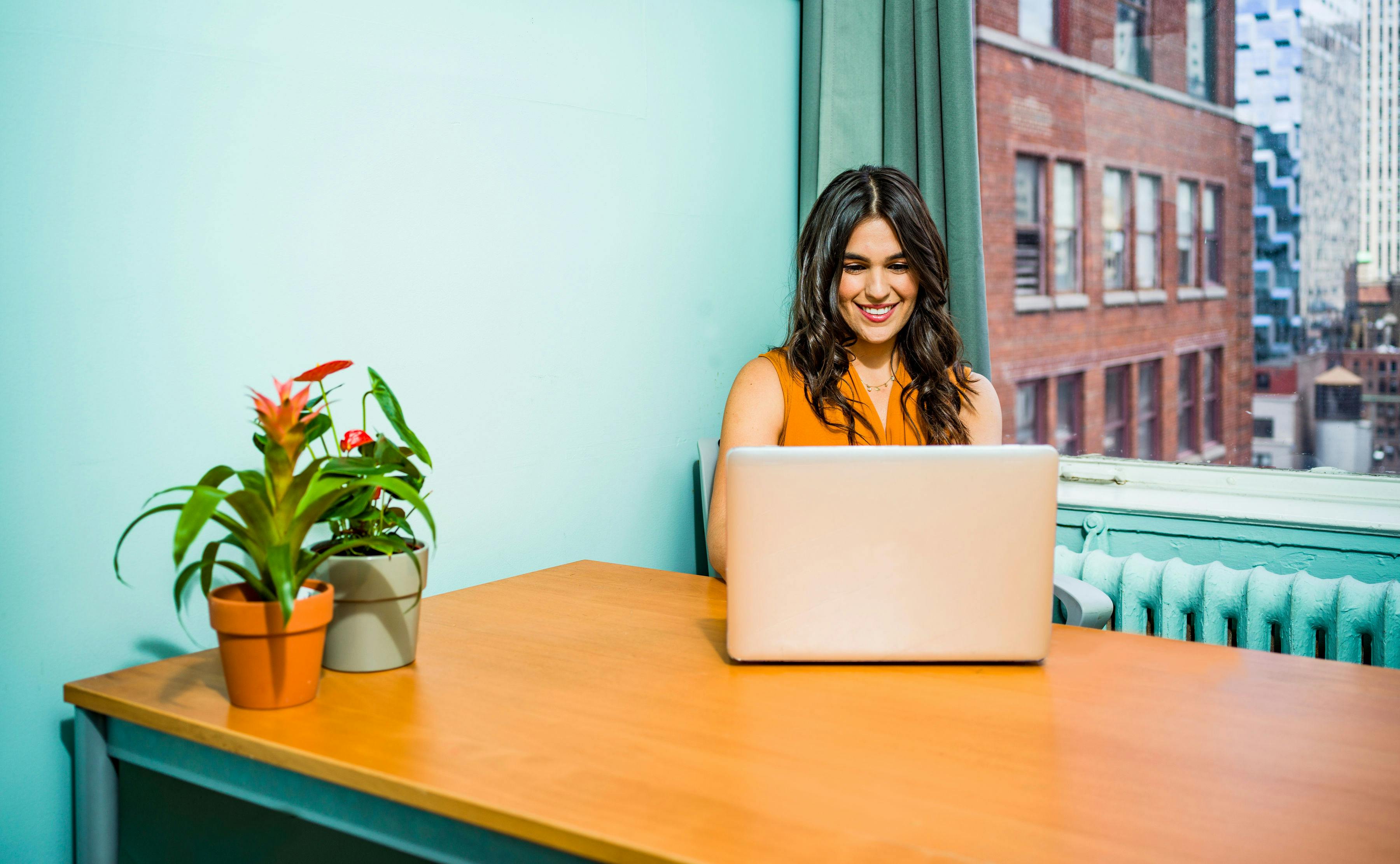 Woman smiling, working on laptop